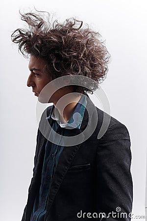 Portrait of a frowning, sad man, with a messy hairstyle, wear in the jacket, isolated on white background. Stock Photo