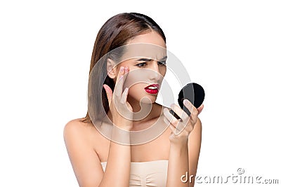 portrait of frowning young woman looking at small mirror Stock Photo