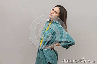 Frustrated anxious unhealthy woman holding hands on lower back, kidney injury, backache. Stock Photo