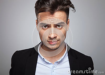 Portrait of frustrated businessman in black suit standing Stock Photo