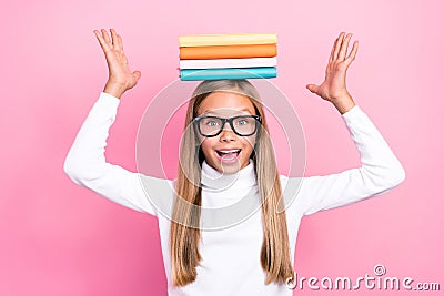 Portrait of funky positive girl pile stack book hold head toothy smile isolated on pink color background Stock Photo