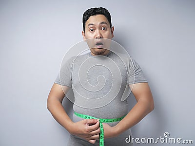 Funny Asian Man SHocked Worried to See His Big Belly, Overweight Problem Concept Stock Photo