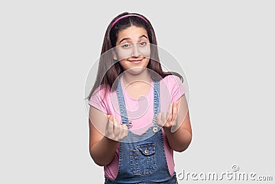 Portrait of funny beautiful brunette young girl in casual style, pink t-shirt and blue overalls standing with italian or money Stock Photo