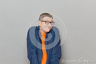 Portrait of funny blond mature man with glasses making goofy grimace Stock Photo