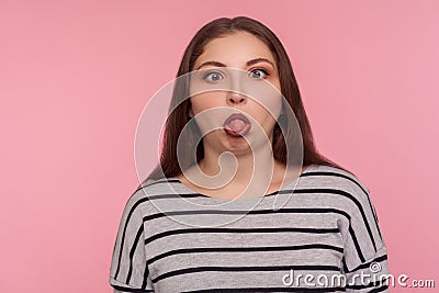 Portrait of funny dumb amusing woman in striped sweatshirt standing with crossed eyes, showing tongue out Stock Photo