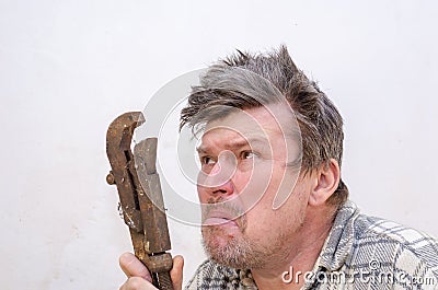 Portrait of a funny geezer with a rusty old dirty pipe wrench Stock Photo