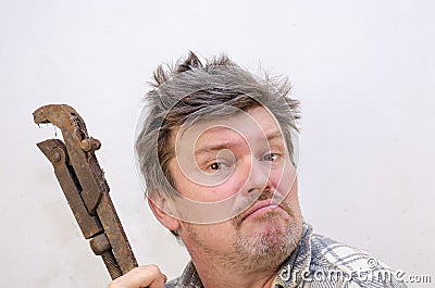 Portrait of a funny geezer with a rusty old dirty pipe wrench Stock Photo