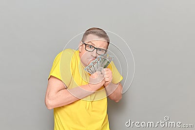 Portrait of funny greedy man holding money in hands Stock Photo