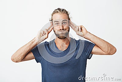 Portrait of funny handsome man with beard making silly faces and gesticulating with hands to attract attention of crying Stock Photo