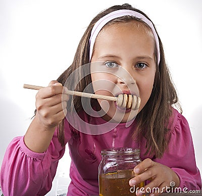 Portrait of funny lovely little girl eat honey Stock Photo