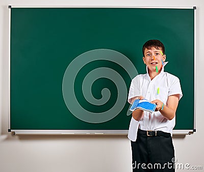 Portrait of funny pupil. School boy very emotional, having fun and very happy, blackboard background - back to school and Stock Photo