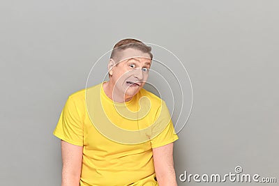 Portrait of funny puzzled mature man making goofy crazy face Stock Photo