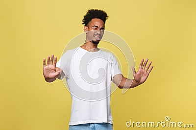 Portrait furious angry annoyed displeased young man raising hands up to say no stop right there isolated orange Stock Photo