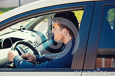 Portrait of furious male driver sitting in the car and honking the car horn angry on the driver ahead Stock Photo