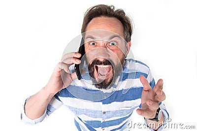 Portrait of furious mature bearded man dressed in shirt with blue lines cry over mobile phone isolated on white background. Stock Photo