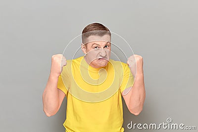 Portrait of furious mature man shaking fists in threatening gesture Stock Photo