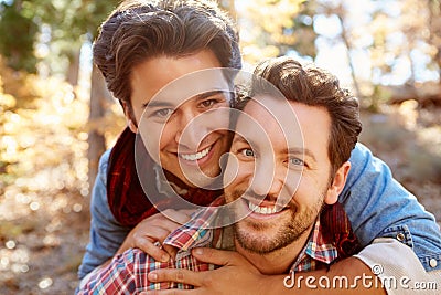 Portrait Of Gay Male Couple Walking Through Fall Woodland Stock Photo