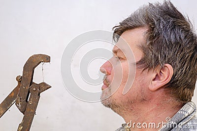 Portrait of a geezer talking with a dusty pipe wrench Stock Photo