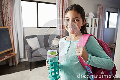 Portrait Of Girl With Backpack In Bedroom Ready To Go To School Stock Photo