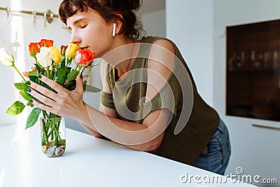 Portrait girl with bouquet of multi-colored roses at home Stock Photo