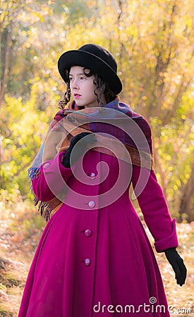 Portrait girl in a bright crimson coat in sunny autumn day outdo Stock Photo