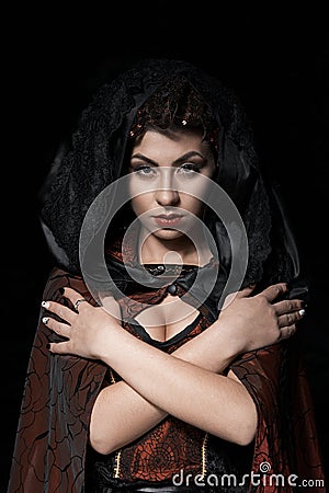 Portrait of a girl dark of the Queen with a crown on her head and make-up isolated on dark background, boobs beauty face Stock Photo