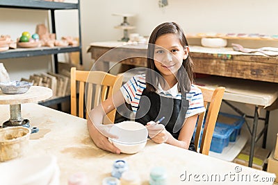 Girl Enhancing Her Pottery Painting Skill In Class Stock Photo