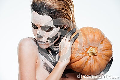 Portrait of girl with fearful halloween makeup holding pumpkin Stock Photo
