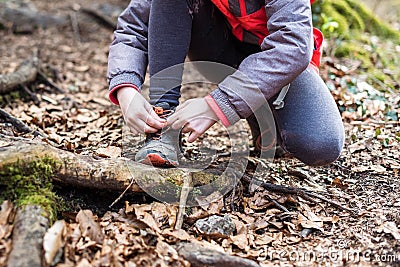 Portrait of girl on hiking forest trip tying shoe laces Stock Photo