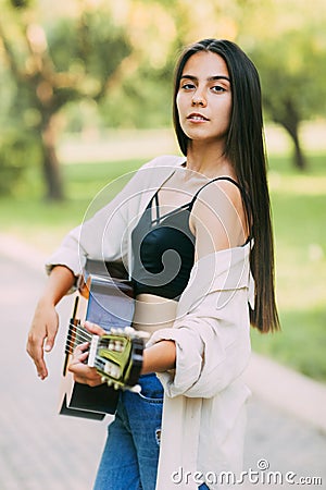 Portrait of a girl-a musician playing the guitar in nature. Vacation, vacation, hobby. Women musicians, music Stock Photo