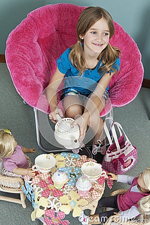 Midsection of girl pretending to have tea party with her dolls Stock Photo