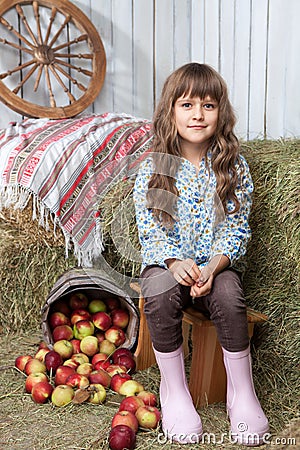 Portrait of girl villager near pail with apples Stock Photo