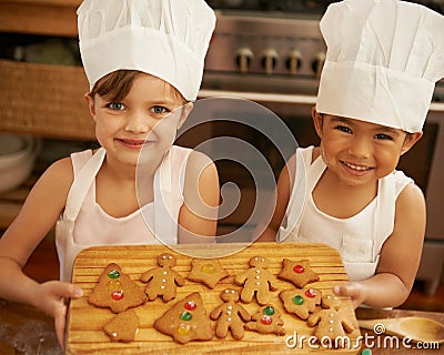 Portrait, girls and Christmas cookies in kitchen, smile and happy for festive, holiday and joy. Xmas, female friends and Stock Photo