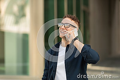 Portrait glad handsome millennial caucasian man student in glasses calling by mobile phone, got good news, talk Stock Photo