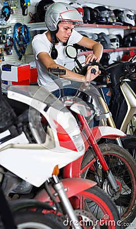Portrait of glad male in helmet on motorbike in the store Stock Photo