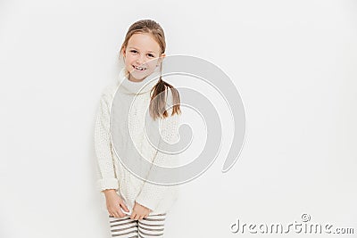 Portrait of glad satisfied girl wears warm white knitted sweater Stock Photo