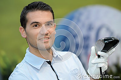 Portrait golfer posing with ball on field Stock Photo