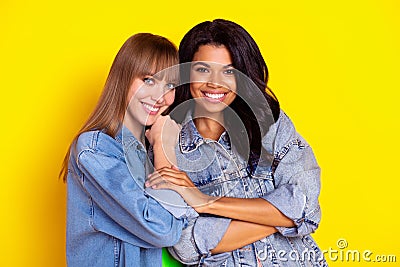 Portrait of gorgeous friendly girls dark skin touch arm look camera beaming smile isolated on yellow color background Stock Photo
