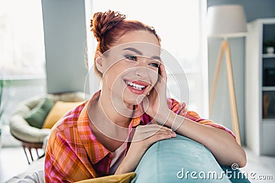Portrait of gorgeous positive female person beaming smile sitting sofa imagine fantasize apartment inside Stock Photo