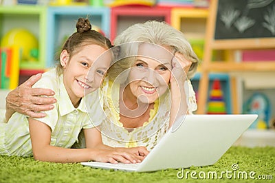 Portrait of grandmother and granddaughter using laptop Stock Photo