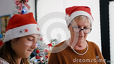 Portrait of grandmother with granddaughter wearing santa hats Stock Photo