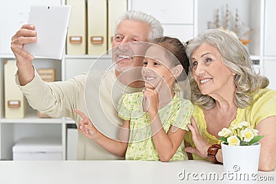 Portrait of grandparents with her granddaughter taking selfie Stock Photo