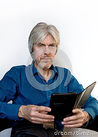 Portrait of a gray-haired elderly man with a short beard, wearing glasses to reflect on the meaning of life, the past years with t Stock Photo