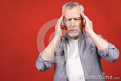 Portrait of a groggy upset worried sad, depressed, tired senior man with a headache, very stressed, isolated on red background, Stock Photo