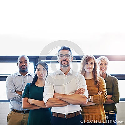 Portrait of a group of confident and serious professionals standing together with arms crossed and copyspace. Serious Stock Photo