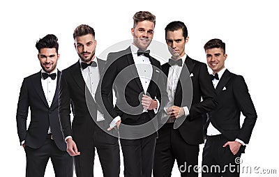 Portrait of group of five elegant men in tuxedoes standing Stock Photo