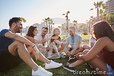 Group of friends sitting outside in circle talking Stock Photo