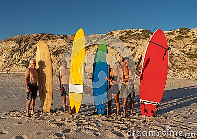 Portrait of group of mature men and woman surfers holding their surfboards on beach Stock Photo