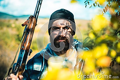 Portrait of hamdsome Hunter. Hunter with shotgun gun on hunt. Man holding shotgun. Big game. Deer hunt. Stock Photo