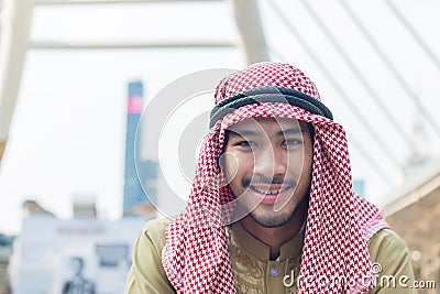 Portrait of handsome arab businessman is smiling in downtown with building background Stock Photo